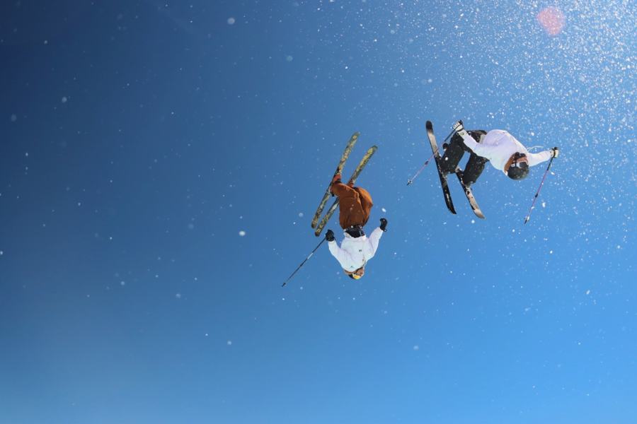 Deux skieurs en saut dans le ciel bleu